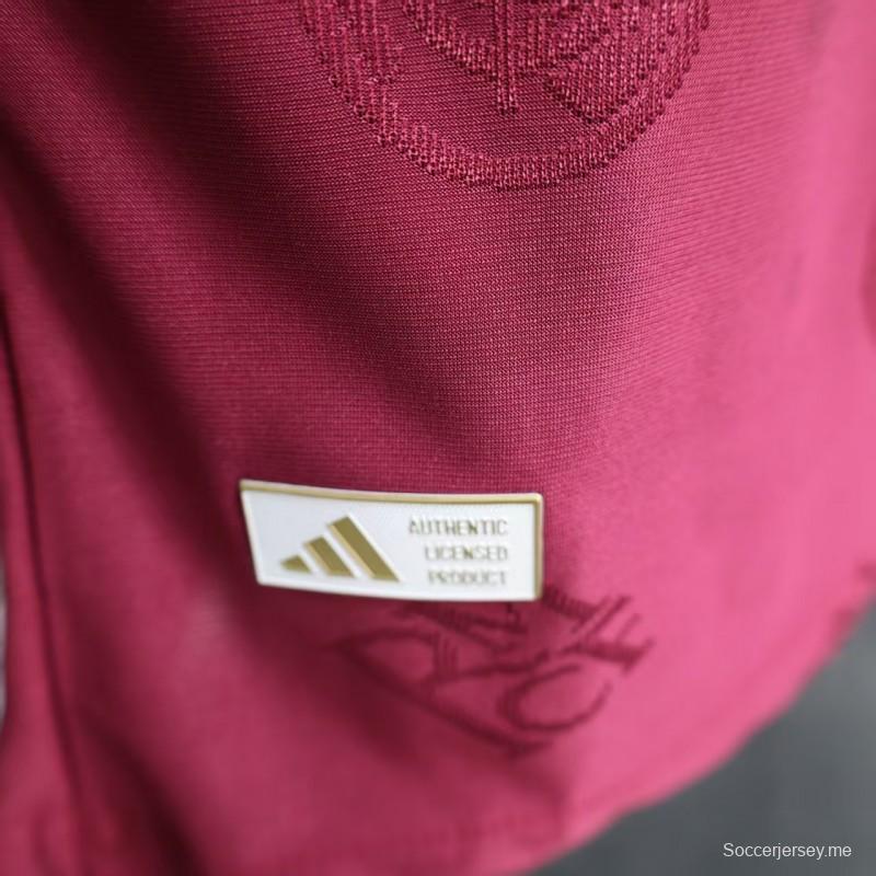 قميص اللاعب نسخة 25/26 لريال مدريد باللون العنابي مع شعار النادي المطبوع على كامل القميص