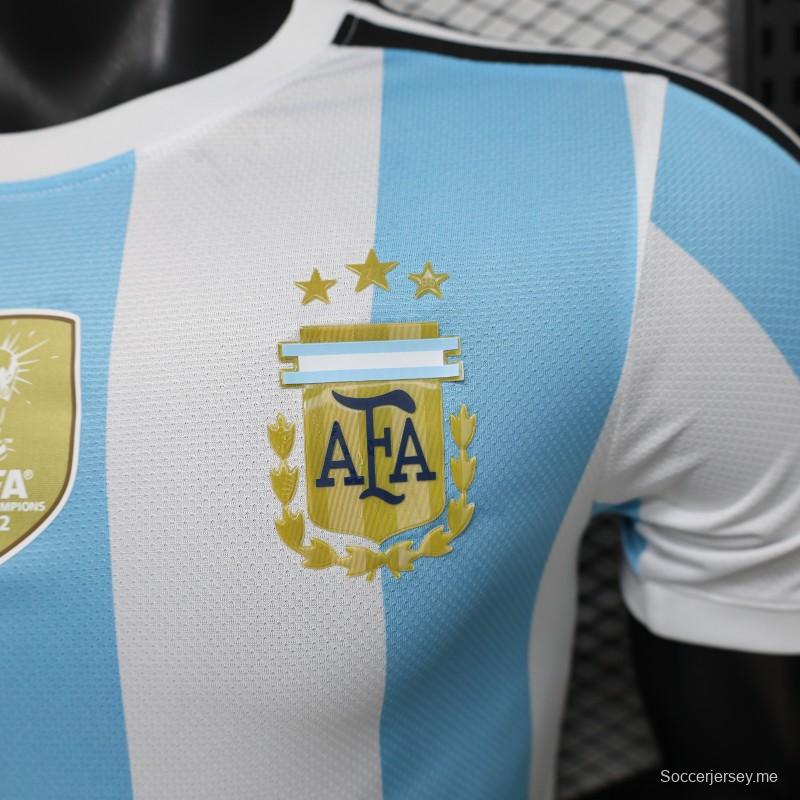 قميص المنتخب الأرجنتيني للمباريات على أرضه، إصدار اللاعب 2027، باللونين الأبيض والأزرق الفاتح مع شارة بطل كأس العالم FIFA