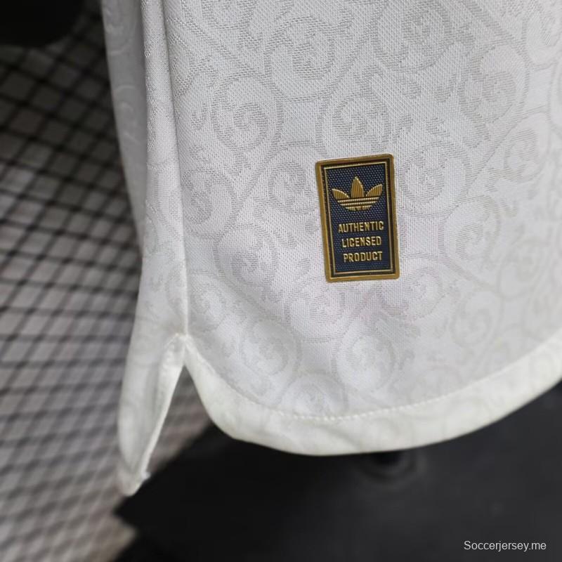 قميص اللاعب خارج أرض الملعب، إصدار 2026، إسبانيا — أبيض مع تفاصيل باللون العنابي والذهبي