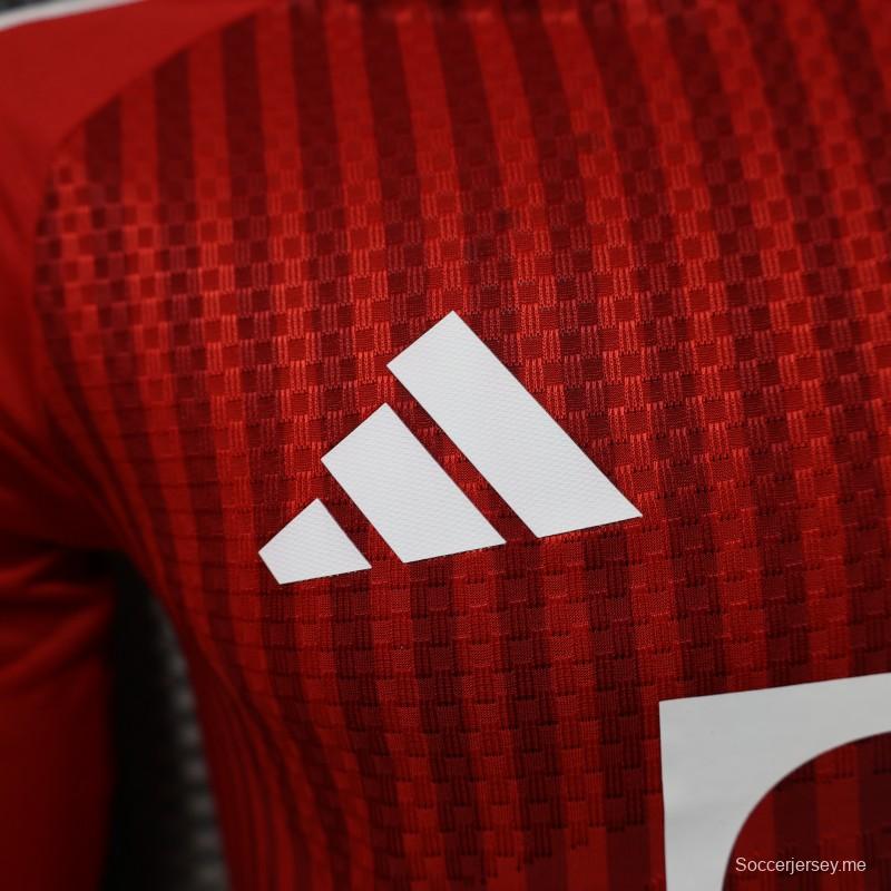 قميص لاعب بنادي بايرن ميونيخ، موسم 2026/2027، باللون الأحمر مع خطوط مائلة باللون الأحمر نفسه، بأكمام طويلة