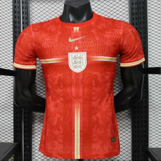 قميص اللاعب الإصدار 2026، قميص إنجلترا خارج أرضها باللون الأحمر مع شعار الأسد الذهبي، إصدار خاص